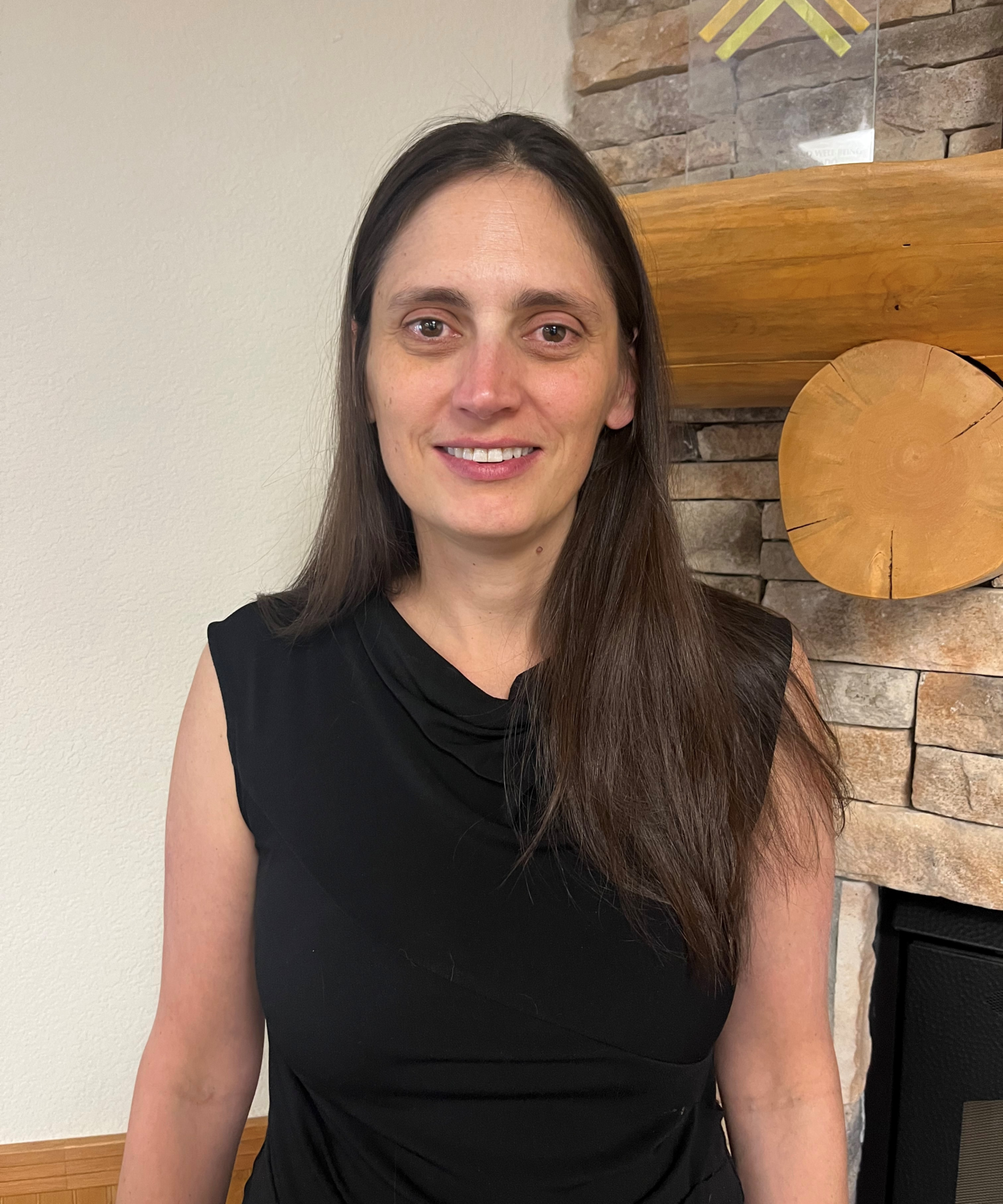 Rebecca Taylor, a woman with long dark brown hair in a black dress photographed at Mountain Resource Center.